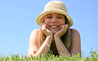 A woman laying down in grass smiling