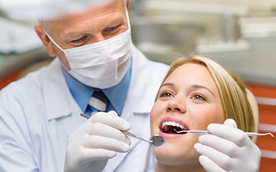 A dentist looking at a young womans teeth