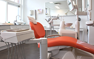An empty dental room with a dental chair and dental equipment