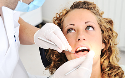 A dentist looking at a womans tooth