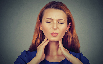 A woman holding her jaw in pain